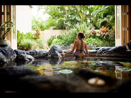 Woman admiring the lush scenery from the hot tub at Kohala Spa, Hilton Waikoloa Village®, Big Island, Hawaii. 