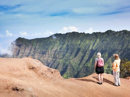 Two hikers enjoying the view from the trails of the lush Waimea Canyon of Kauai