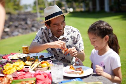 Father and daughter enjoying Hawaiian cuisine, Oahu, Hawaii. 
