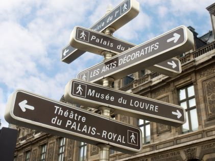A signpost with directions to various attractions in Paris