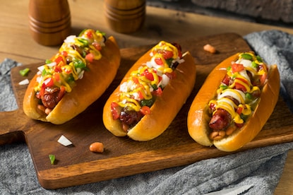 Three homemade Sonoran hot dogs topped with bacon, mustard and mayonnaise