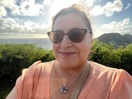 A Hilton Grand Vacations Member taking a vacation selfie in front of a sunset in Sint Maarten