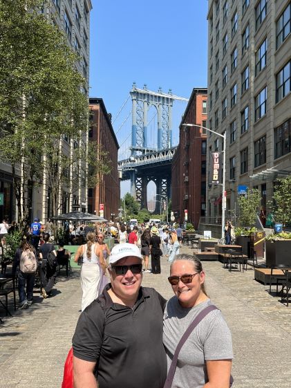 Two Hilton Grand Vacations Members in front of the Manhattan Bridge on vacation to New York