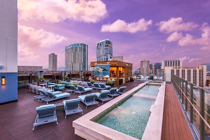 Sunset view of the rooftop plunge pool and lounge at Hokulani Waikiki, a Hilton Grand Vacations Club, Honolulu, Hawaii