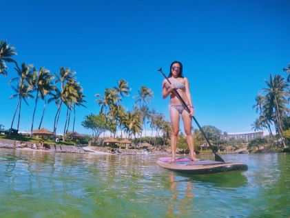 A Hilton Grand Vacations Member on a paddle board in Hawaii