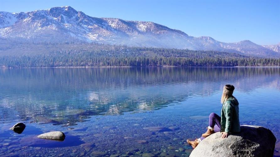 A Hilton Grand Vacations Member sits by the lake at South Lake Tahoe