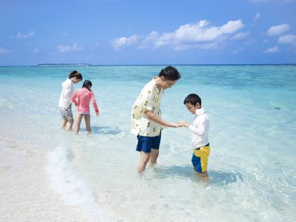 A family playing in the water of Sesoko Island, Japan
