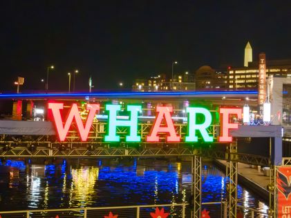A neon sign for the Wharf in Washington, D.C., at night