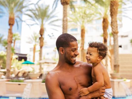 A father holds his young son at a pool in Las Vegas