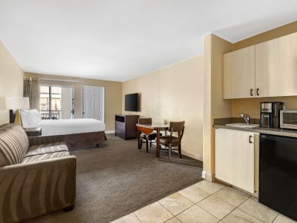 Studio at Palm Canyon Resort in Palm Springs, California, featuring a queen-size bed, couch and kitchenette