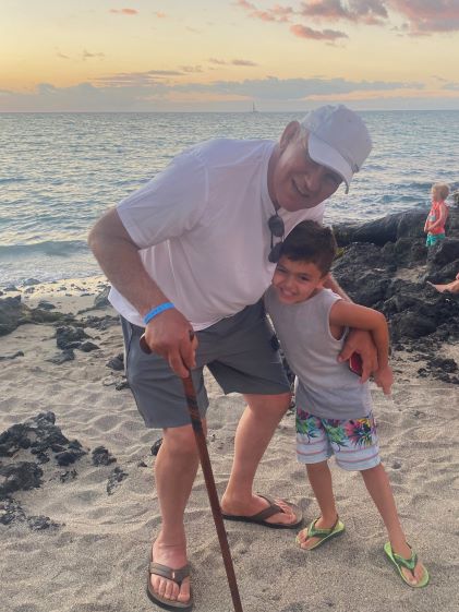 A Hilton Grand Vacations Member's son hugs his grandpa while on vacation on the Big Island