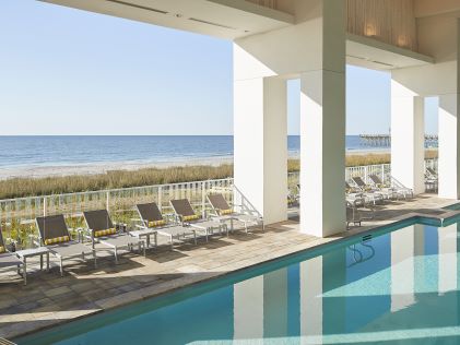 Beachside pool and lounge chairs at Ocean Enclave, a Hilton Grand Vacations Club in Myrtle Beach, South Carolina