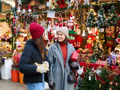 Two women shop at a Christmas market