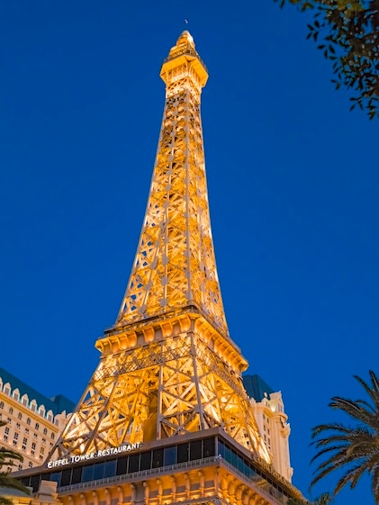 Nighttime view looking up at the glowing lights of Eiffel Tower at the Paris hotel and casino in Las Vegas, Nevada.