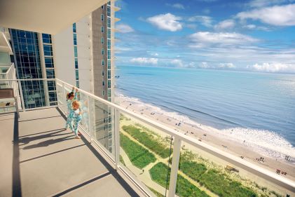 Two kids enjoying spacious balcony, beautiful oceanfront view, Ocean Enclave, a Hilton Grand Vacations Club, Myrtle Beach, South Carolina. 