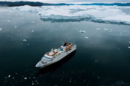 Beautiful aerial image, cruise ship sailing through iceberg dotted waters.